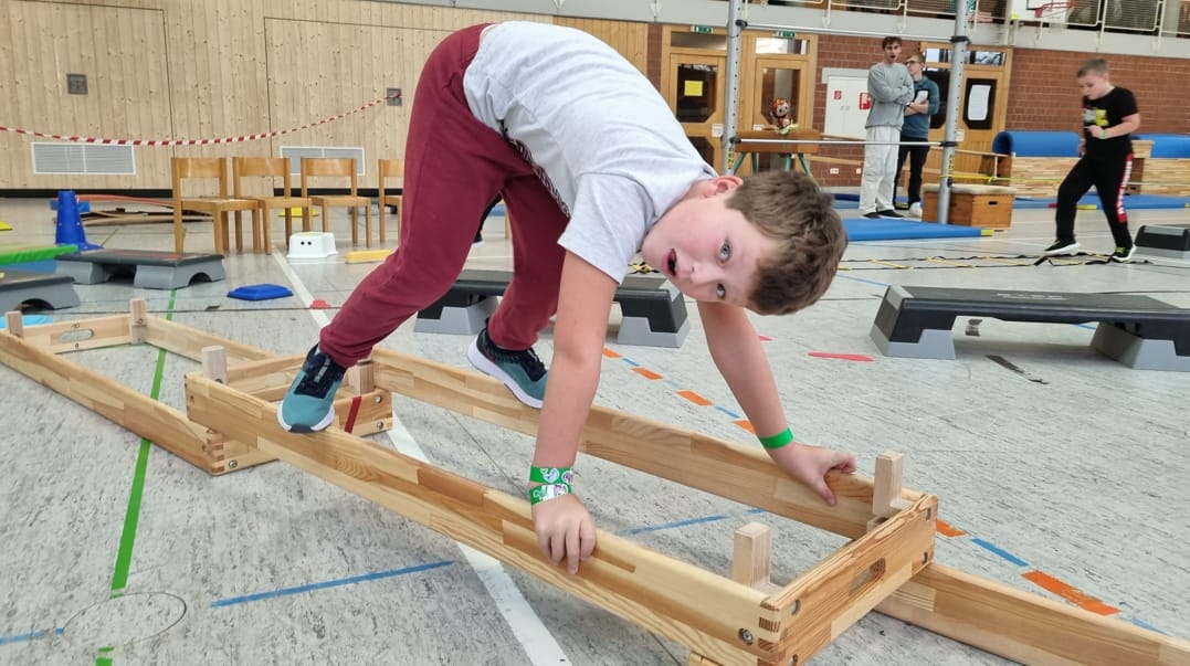 Junge balanciert über eine Holzleiter