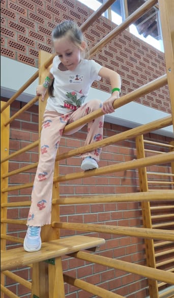 Mädchen klettert an der Sprossenwand