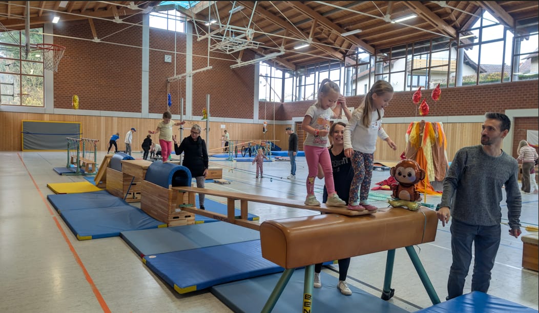 Kinder mit Eltern am Schwebebalken
